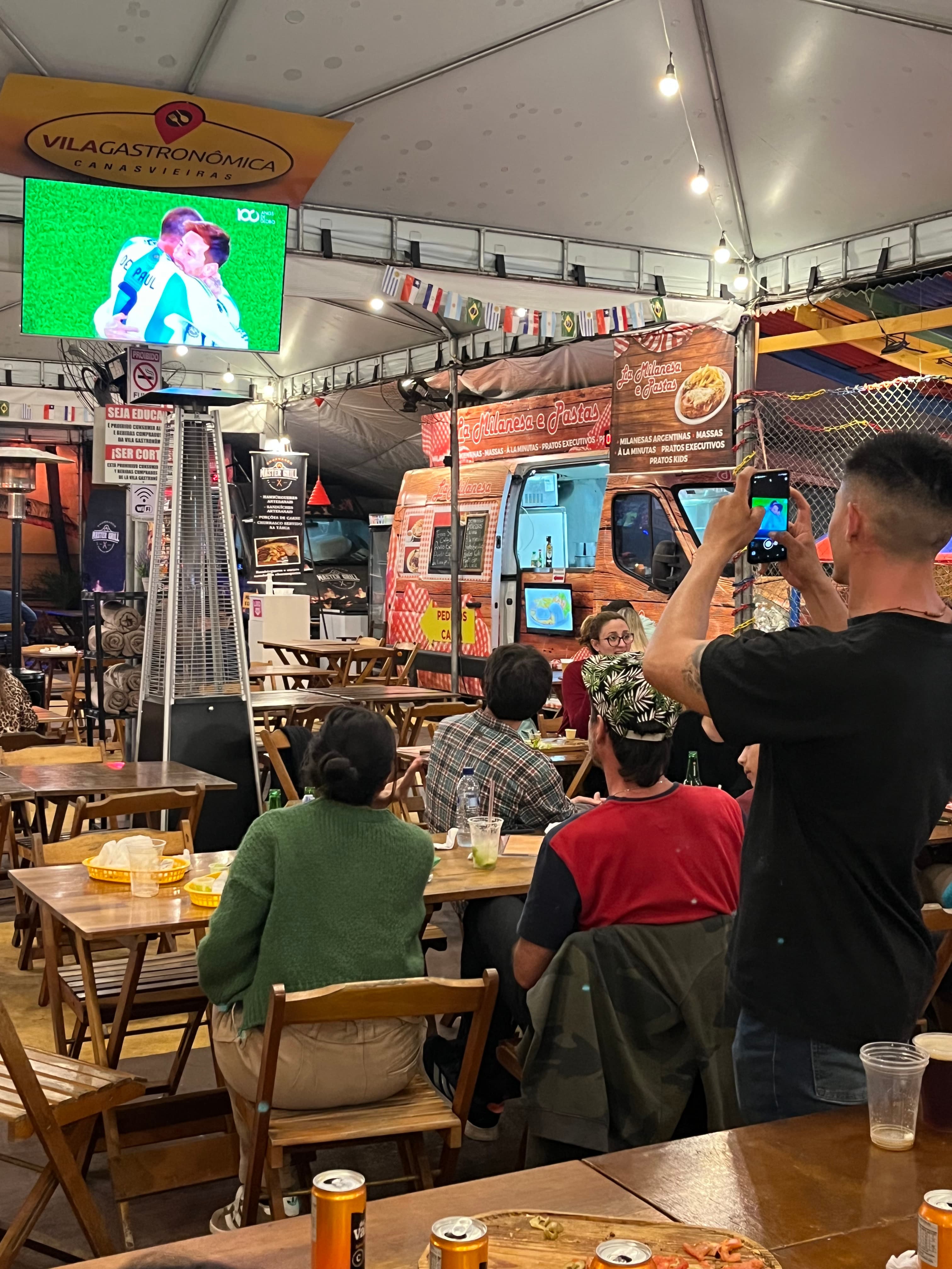 Salão principal com TVs e ambiente animado